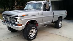 a gray truck parked in front of a garage