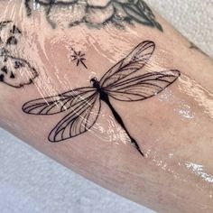 a dragonfly tattoo on the left arm