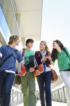 four young people are walking together with their luggage