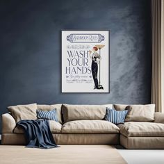 a living room with a couch and a poster on the wall above it that says wash your hands