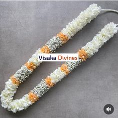 two white and orange flower leis on a gray background with the words visaka divines