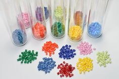 many different colored beads in glass containers on a white surface with space for the wording