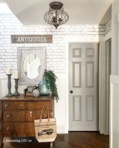 a white brick wall in a room with a wooden dresser and mirror on top of it