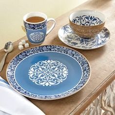 a blue and white dinner set on a wooden table