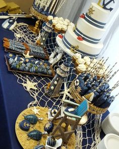 a table topped with cakes and desserts on top of a blue cloth covered table