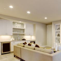 a living room filled with furniture and white cabinets