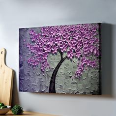 a painting with purple flowers on it next to a cutting board