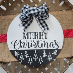 a merry christmas sign is hanging on a basket with burlocks and red ribbon