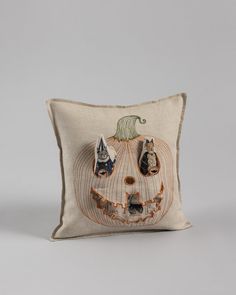 a pillow with an embroidered pumpkin on it