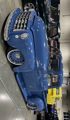 an old blue car is parked in a garage