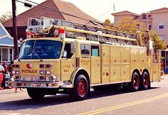 a yellow fire truck driving down the street