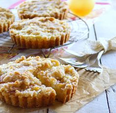 three muffins sitting on top of a wooden table next to a glass plate