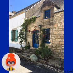 an old stone house with blue windows and shutters on the outside, surrounded by greenery