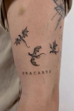 a man with a tattoo on his arm that saysdracarryss and two flying bats