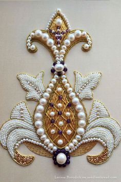 an embroidered brooch with pearls and beads