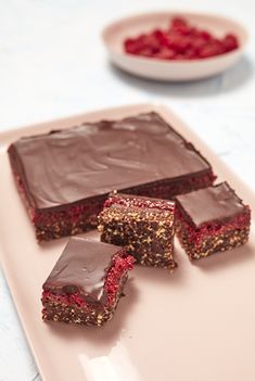 three pieces of chocolate and raspberry cake on a plate