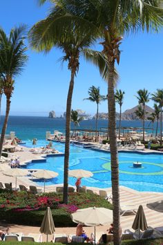 a large pool with palm trees next to it