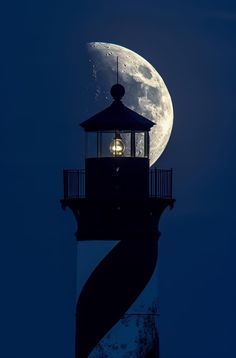 a lighthouse with a full moon in the background