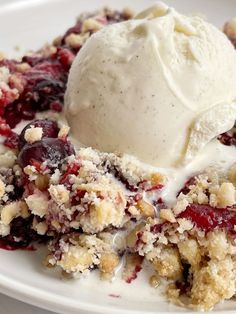 a white plate topped with fruit cobbler and ice cream