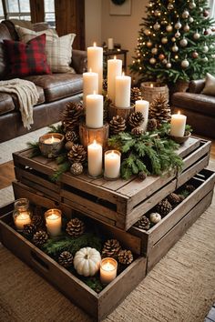 candles and pine cones are arranged on top of wooden crates in front of a christmas tree