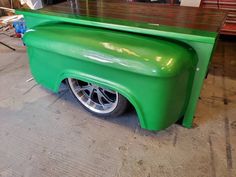 a green truck is parked in a garage