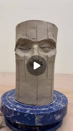 a clay face sitting on top of a blue object