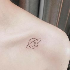 a woman's shoulder with a small cat tattoo on the left side of her chest