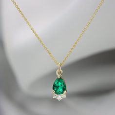 Beautiful drop pendant with three diamonds framing the bottom. Perfect mix of elegance and charm in one necklace. Great worn on its own or can be layered with more gold necklaces to add a bit more fun. The emeralds rich green is balanced well by the three diamonds that sit along the bottom. All Custom requests are welcome! Other gemstones are available including Sapphire, Ruby, Tourmaline, Diamonds and many more.Features:•Center Stone: Chatham emerald pear cut 7x5  mm 0.57ct•Secondary Stone: 3 d Green Diamond Drop Necklaces, Emerald Teardrop Pendant Fine Jewelry Necklace, Emerald Teardrop Pendant Necklace Fine Jewelry, Pear-shaped Green Emerald Necklaces, Green Pear-shaped Emerald Necklaces, Fine Jewelry Emerald Pear Necklace, Emerald Pendant Diamond Necklace For May Birthstone, Emerald Diamond Pendant Necklace For May Birthstone, Emerald Teardrop Pendant Necklace For May Birthstone