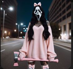 a woman with long black hair wearing a pink sweater and white mask holding a skateboard