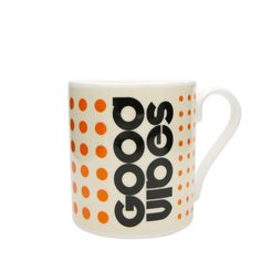 a white coffee cup with orange dots on it and the words good dogs written in black