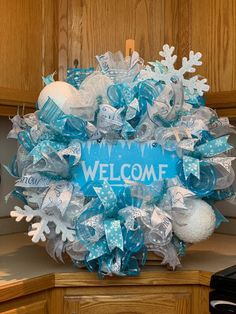 a welcome wreath with blue and white decorations