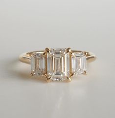 three stone diamond ring in yellow gold with baguets on the sides and side stones