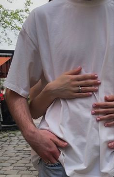 a man and woman standing next to each other with their hands on their hipss