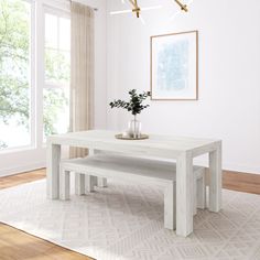 a white table with two benches in front of it and a potted plant on top