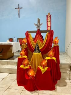 the altar is decorated with red and yellow cloths, candles, and crosses on it