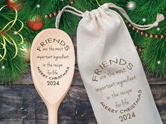 two wooden spoons with personalized designs on them next to a christmas ornament