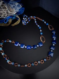 This is a very long ethnic style necklace made with large square dragon venis agate stones dyed blue. The necklace is asymmetrical with copper-plated brass decorative elements. To finish the necklace I used agate stones in different shapes. The necklace in the classic chain necklace style, very suitable for a single color dress or winter sweater. For those who love elegant retro style. All jewels are delivered in a decorated box, ready to be given as a gift to your loved one. How to take care of your jewellery: put on your beauty products (cosmetics, perfumes, ...) before wearing your precious jewel. Clean your jewelry with a soft cloth after wearing. Don't use water. Make sure you store your jewelry separately to avoid scratching it. Store away from heat sources, in a dry place in the spe Blue Square Necklace For Gifts, Blue Square Necklace For Gift, Blue Square Necklace Perfect For Gifts, Bohemian Blue Rectangular Necklace, Handmade Blue Rectangular Necklace, Bohemian Blue Necklace With Rectangular Pendant, Handmade Blue Long Necklace For Gift, Bohemian Blue Rectangular Pendant Necklace, Blue Necklace With Natural Stones In Rectangular Pendant