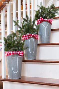 two potted plants with the letter j on them are sitting on some steps decorated with red and white ribbon