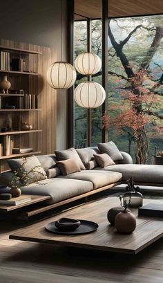 a living room filled with lots of furniture and large windows overlooking the trees in the forest