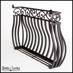 a black metal shelf with an ornate design on the top and bottom, against a white background