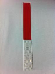 a red and silver object on a white surface in the shape of a toothbrush