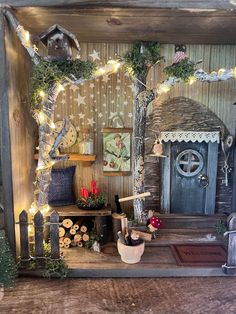 a doll house with fairy lights and decorations on the front door, sitting on a wooden table