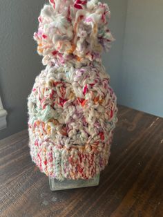 a crocheted vase sitting on top of a wooden table