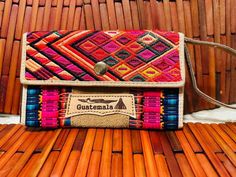 a colorful purse sitting on top of a wooden bench