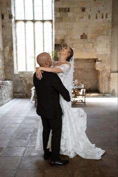 the bride and groom are posing for their wedding photo in an old castle like setting