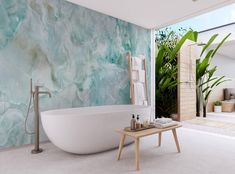 a large white bath tub sitting in a bathroom next to a wooden table and potted plants