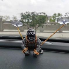 a gorilla figurine sitting on the dashboard of a car with two lights attached to it