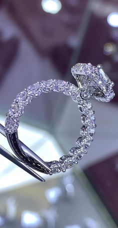 a diamond ring is being held by a pair of scissors