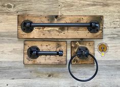 two wooden hooks with metal handles on top of wood planks and one has a round handle