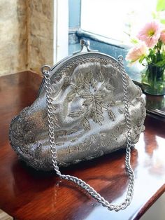 D*E*S*C*R*I*P*T*I*O*N Beautiful quality, vintage genuine 1920s purse. The bag is hand embellished with beaded floral patterns. Looks so elegant and it is in wonderful conditions. Truly recommend this vintage item. S*H*I*P*P*I*N*G Expedited shipping offered with discounted rate of €25 - time of delivery (2-4 days depending on your location) R*ET*U*R*N P*OL*I*C*Y We don't offer returns on earrings. Necklaces bracelets and headpieces could be returned within 3 days from receiving. Art Deco Bags Vintage Purses, Vintage Embellished Pouch Bag, Vintage Embroidered Evening Bag For Party, Silver Embroidered Evening Bag, Vintage Embroidered Clutch Evening Bag, Antique Clutch Evening Bag For Vintage Events, Antique Style Clutch For Vintage Events, Vintage Embellished Clutch Evening Bag, Vintage Handmade Evening Bag For Events